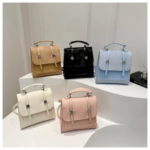 Dettaglio di cinque zaini eleganti in marrone nero blu beige e rosa con fibbie decorative