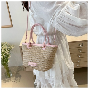 Detail of straw bucket bag with pink leather trim and 'FASHION & BAG' label on the front