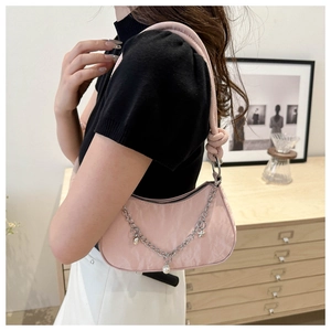 Détail du sac bandoulière rose avec chaîne argentée, perles et étoiles