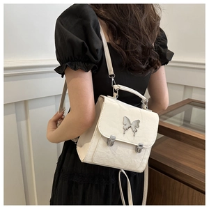 Close-up of a cream butterfly-themed versatile crossbody backpack with metal buckle detail