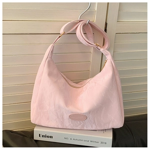 Detailed close-up of pink pleated fabric texture and metal zipper on trendy shoulder bag