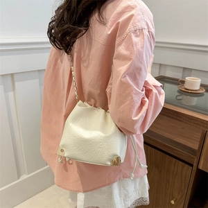 Chic cream white drawstring bucket bag with gold chain strap in minimalist Korean style