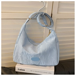 Detail of light blue crinkled hobo bag with adjustable strap and textured fabric