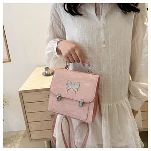 Detail of light pink faux leather backpack with silver butterfly clasp and adjustable straps