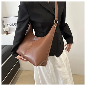 Detail view of brown leather hobo bag with gold ring buckle and vertical seam stitching