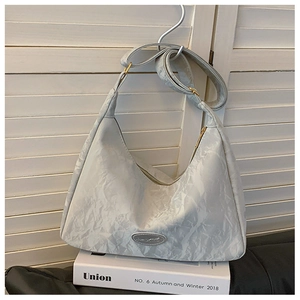 Detail of grey hobo bag with marble texture, adjustable strap and gold hardware accents