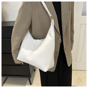 Detail showing white large hobo tote bag texture with vertical stitching and metal rings