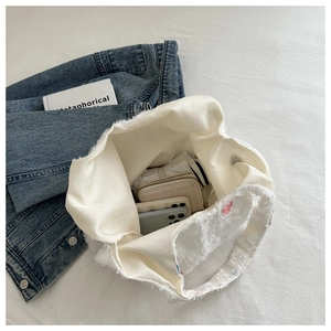 Vue intérieure d'un grand sac cabas blanc montrant le rangement du portefeuille