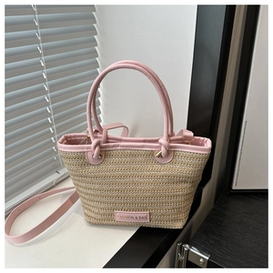 Detailed texture of hand-woven straw tote bag with elegant pink leather trim and handle