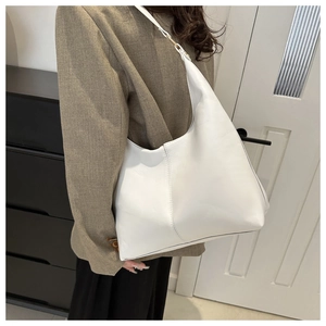 Detailed side view of white leather hobo shoulder bag with decorative topstitching