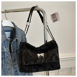 Detail of black PU leather shoulder bag with silver butterfly charm and chain strap