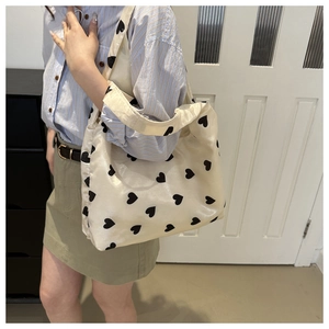 Grand sac cabas beige avec motif à cœurs et matériau en nylon durable en gros plan