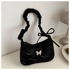 Detail of black pleated shoulder bag with silver butterfly buckle and scrunchie handle