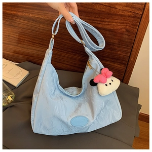 Light blue pleated tote bag detail with cute plush doll pendant and leather logo patch
