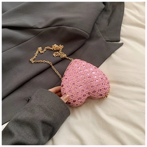 Pink heart-shaped evening bag with shimmering rhinestones and a gold chain strap