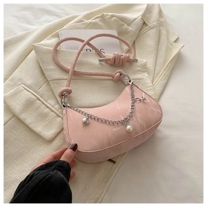 Détail du sac demi-lune rose avec texture pierre et bandoulière à chaîne et breloques