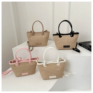Close-up of woven straw bucket bags in four colors with leather trim and shoulder straps