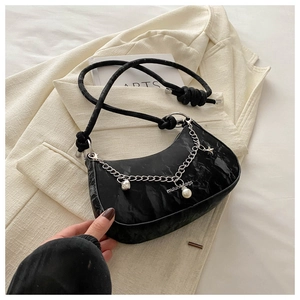 Détail du sac à bandoulière noir effet marbre avec chaîne argentée et breloques