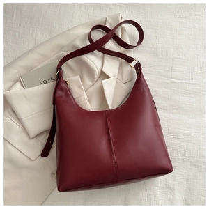 Detailed top view of a dark red hobo tote bag on a white blazer background