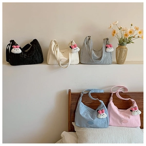 Detail view of nylon tote bags in multiple colors with plush bunny charms for women