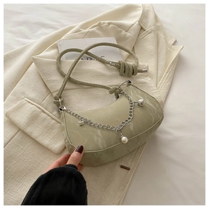 Détail du sac demi-lune vert clair à texture marbrée avec des breloques étoiles