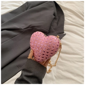 Detail of pink heart-shaped evening clutch with sequins and gold chain strap