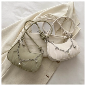 Détail de sacs hobo à motif marbré, chaînes en métal et sangle tissée sur blazer beige