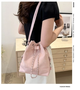 Pink drawstring bucket bag with silver metal chain and fashion brand logo detail