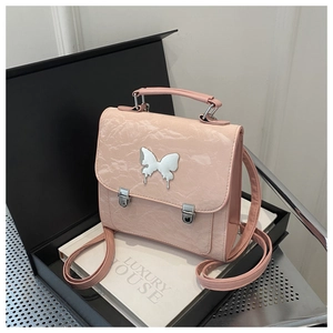 Close-up of pink crinkled patent leather backpack with silver butterfly metal buckle