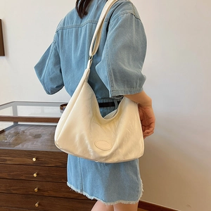 Minimalist cream white oil-wax leather hobo bag with adjustable strap on model