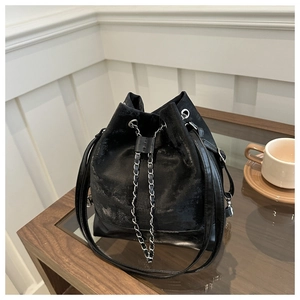 Detail of black velvet bucket bag featuring silver chain drawstring and fashion logo