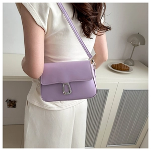 Lavender purple leather shoulder bag shown on model in a minimalist indoor setting