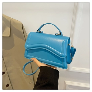 Détail du sac à bandoulière bleu avec rabat ondulé et ornements dorés élégants