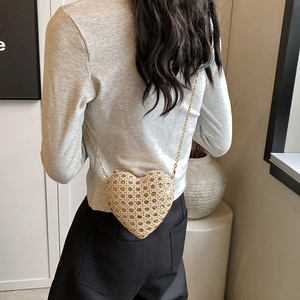 Champagne gold heart shaped clutch bag with fine woven texture and elegant metal chain