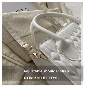 Detail of white quilted leather bag showing refined stitching and gold-tone hardware