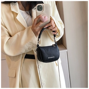 Detail of black litchi texture handbag with silver star studs and bead chain strap