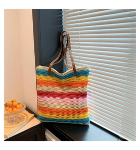 Detail of colorful striped crochet tote bag with durable brown leather handles