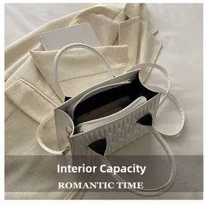 Top view of white quilted square bag showing spacious interior with black lining