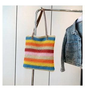 Detailed view of the woven texture on a colorful striped crochet tote bag with leather handles
