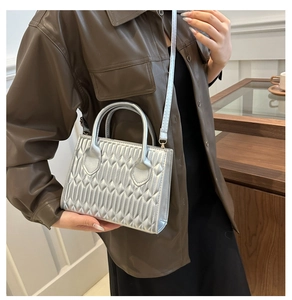 Silver metallic crossbody bag featuring elegant quilted texture and fine shoulder strap