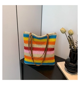 Detailed view of colorful striped woven tote bag with brown leather handles on display