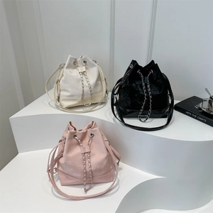 Three elegant chain bucket bags in beige, black and pink with drawstring closures