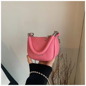 Detail of pink lychee leather mini bag with silver chain strap and top handle