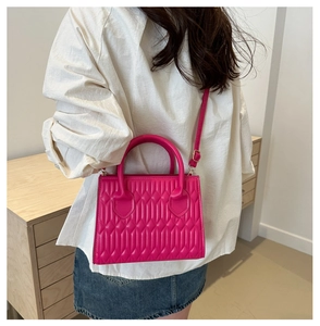 Bright pink quilted handbag shown with casual outfit for size and styling perspective
