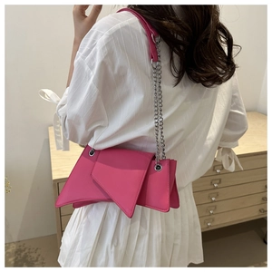 Side view of vibrant magenta geometric shoulder bag with chunky silver chain strap