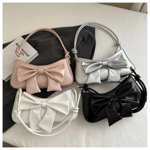Detailed flat lay of chic bow shoulder bags in pink, silver, white, and black colors