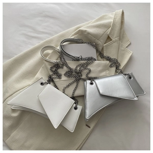 Detail view of modern asymmetric chain shoulder bags in matte white and silver finish