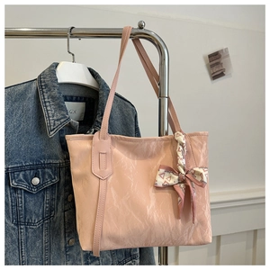 Pink pleated tote bag detail showing the silk scarf ribbon with fashion lettering