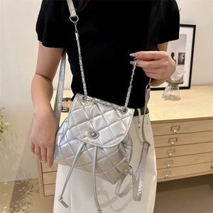 Chic silver quilted diamond lattice backpack with chain strap shown on a model