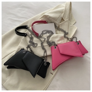 Detailed view of asymmetric chain shoulder bags in black and magenta faux leather